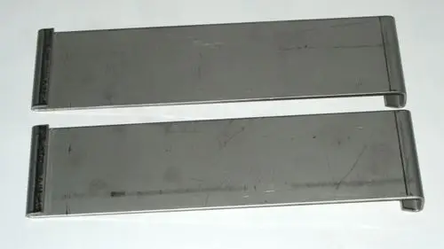 Zwei metallene Clips in länglicher Form, die möglicherweise als Zubehör für ein Daikin Produkt dienen. Sie sind einfach und ohne zusätzliche Merkmale gestaltet.